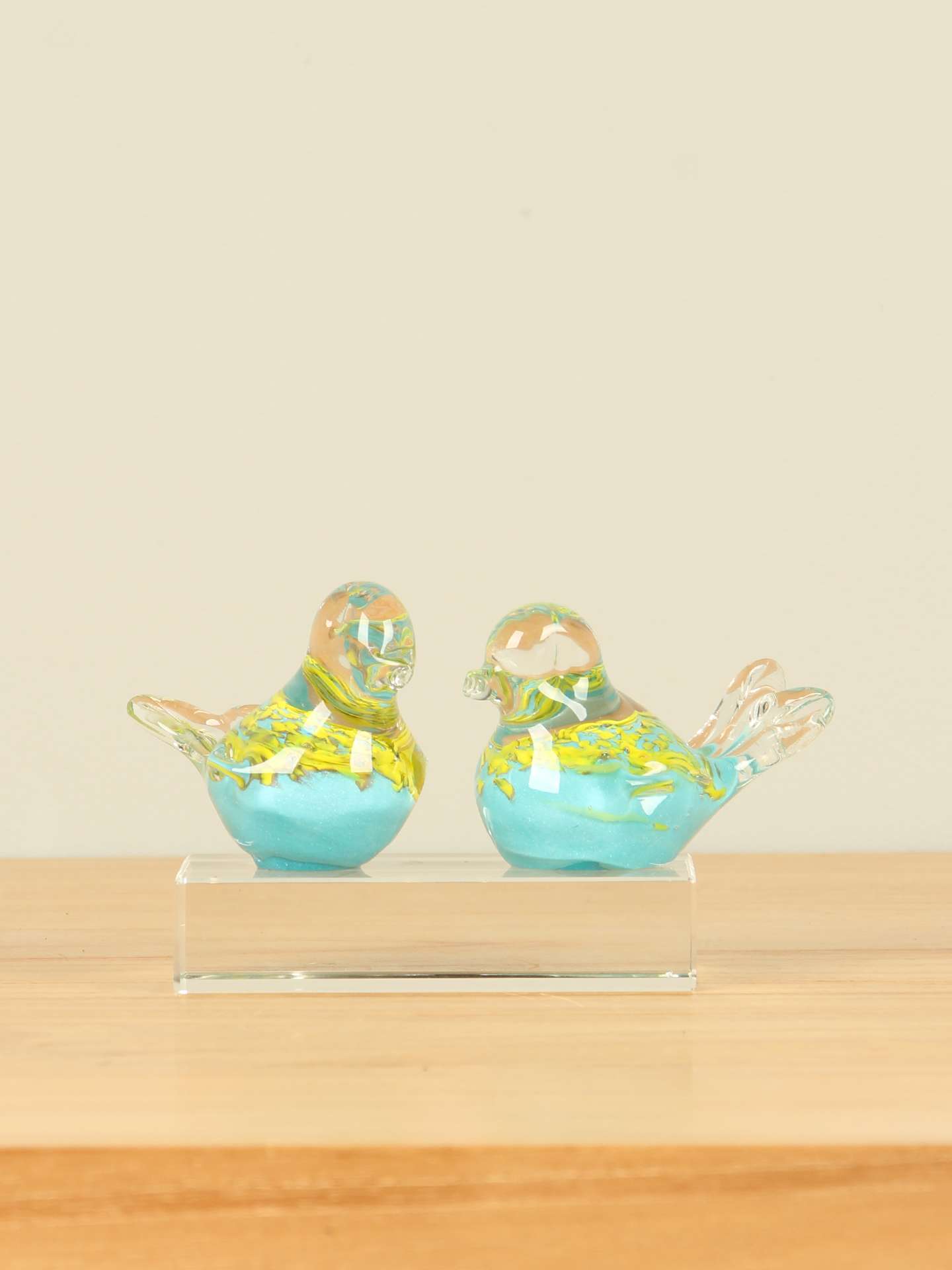 2 glazen vogeltjes op een glazen sokkeltje